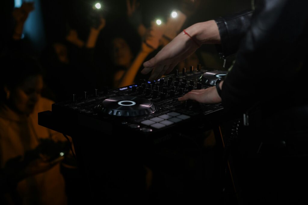 A DJ performing at a nightclub with a lively crowd.